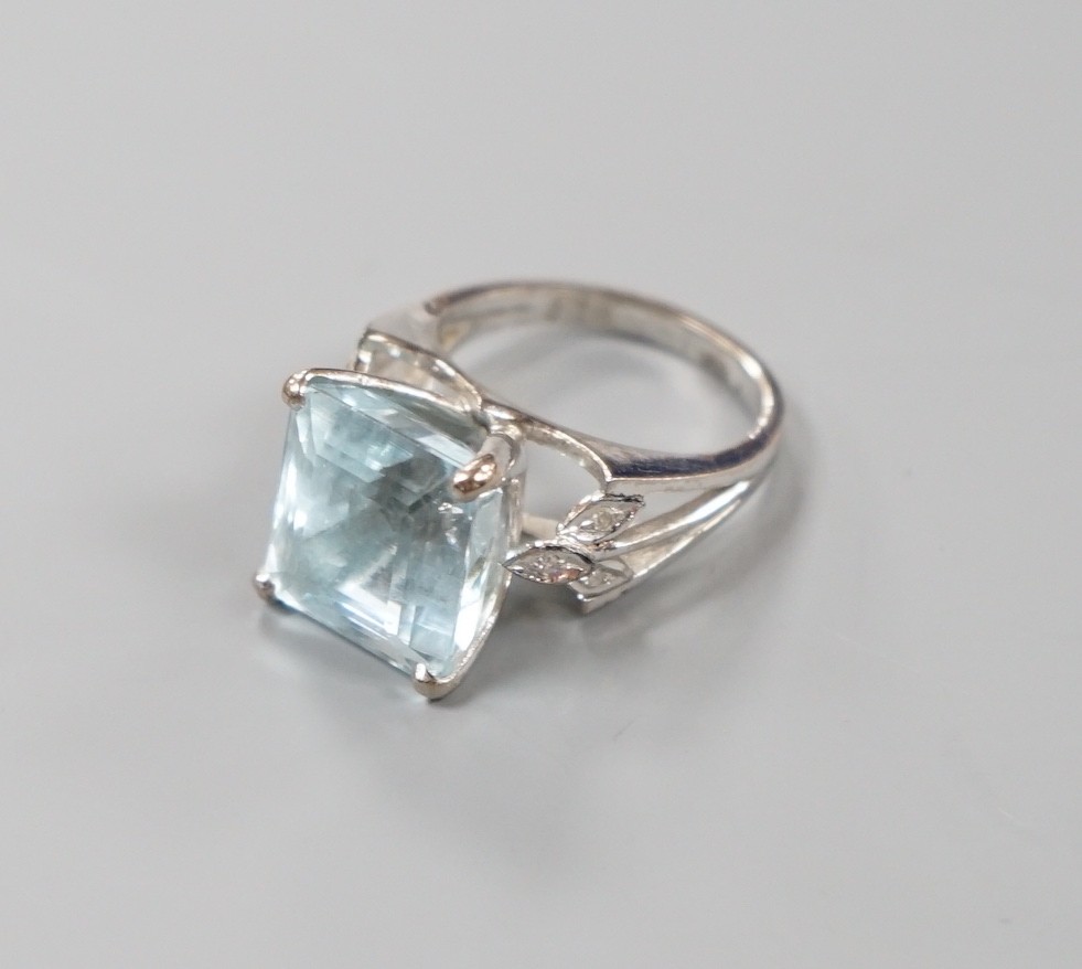 A white metal and single stone square cut aquamarine set dress ring, with diamond set shoulders, size K, gross weight 7 grams.